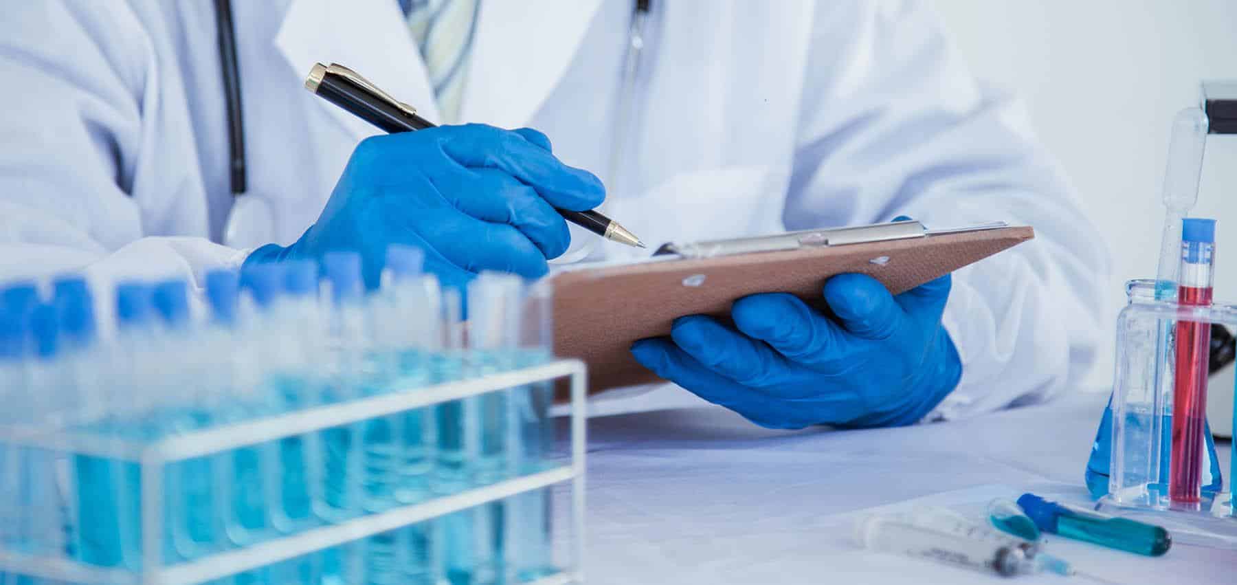 Clinical trial researcher noting test results on a clipboard