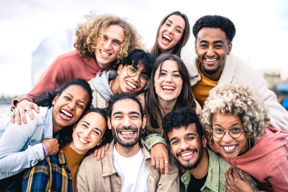 Group portrait of paid clinical trial participants hugging and standing outside.