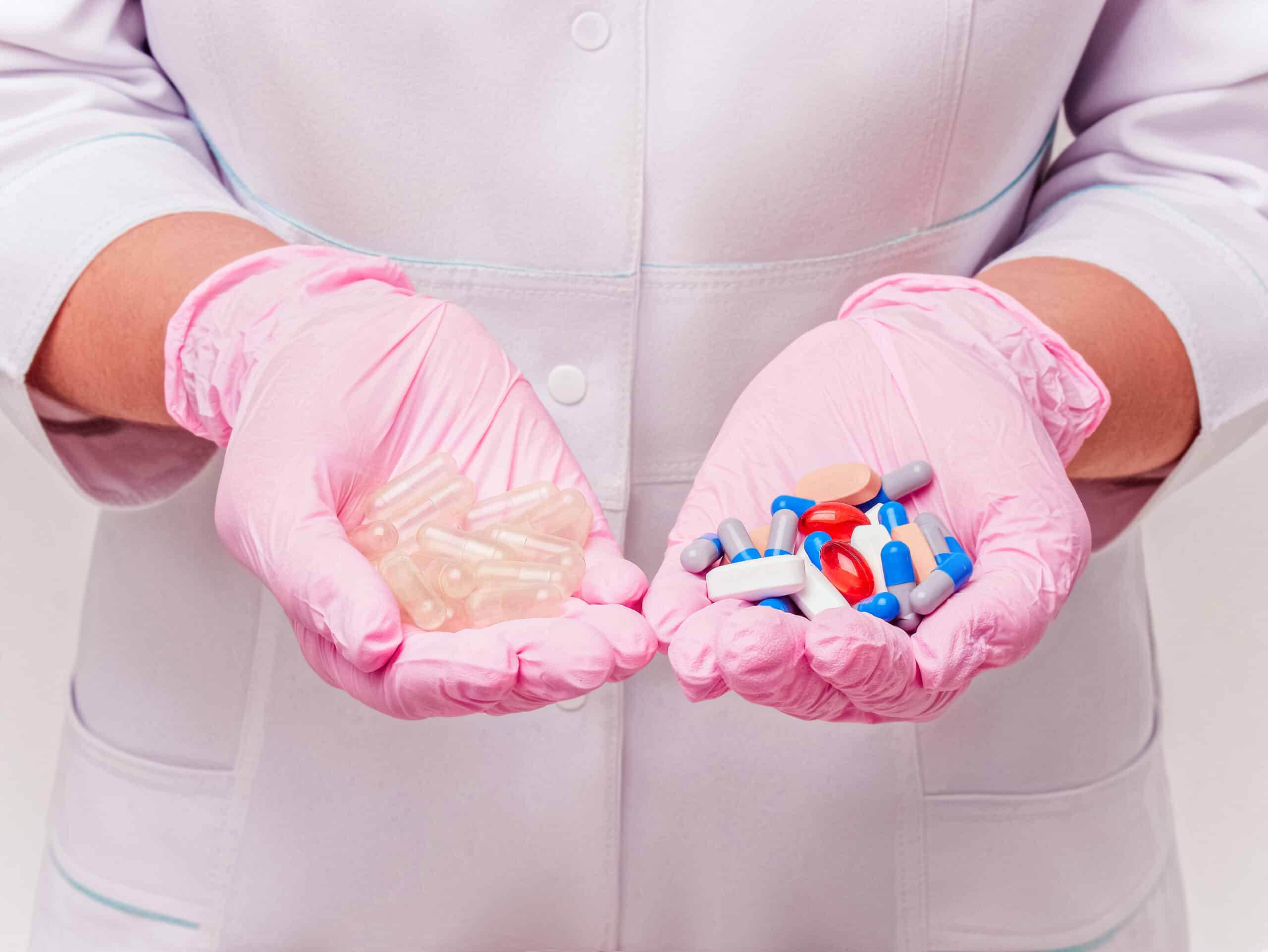 A clinical trial researcher holding the placebo pills in one hand and trial pills in the other.